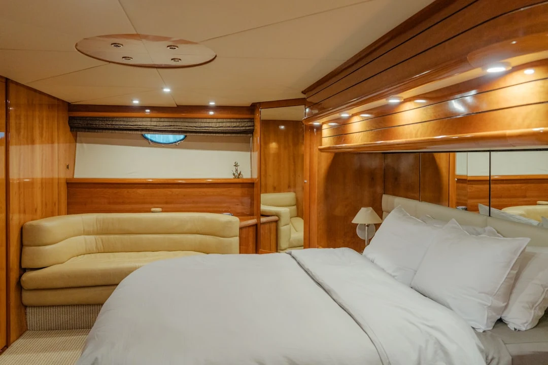 Luxury sailing yacht master cabin: spacious, modern design, plush bedding, large windows, elegant furnishings.